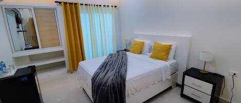 Un dormitorio moderno con cama, mesita de noche y espejo.