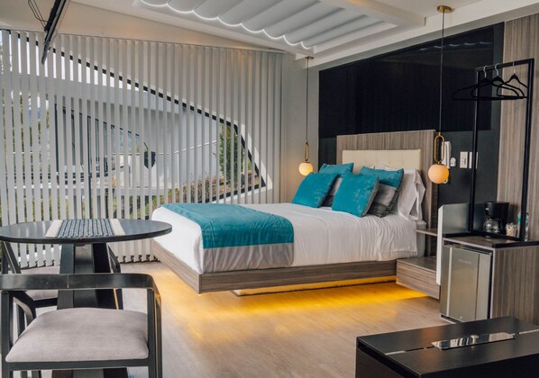 Un dormitorio moderno con cama, mesitas de noche, escritorio y una silla.