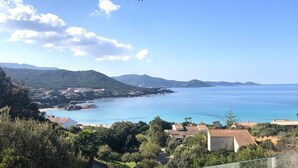 A terrace with a view of a coastal landscape, including a body of water and distant hills. - Apartment 2 minutes from Ruppione beach (Pietrosella)