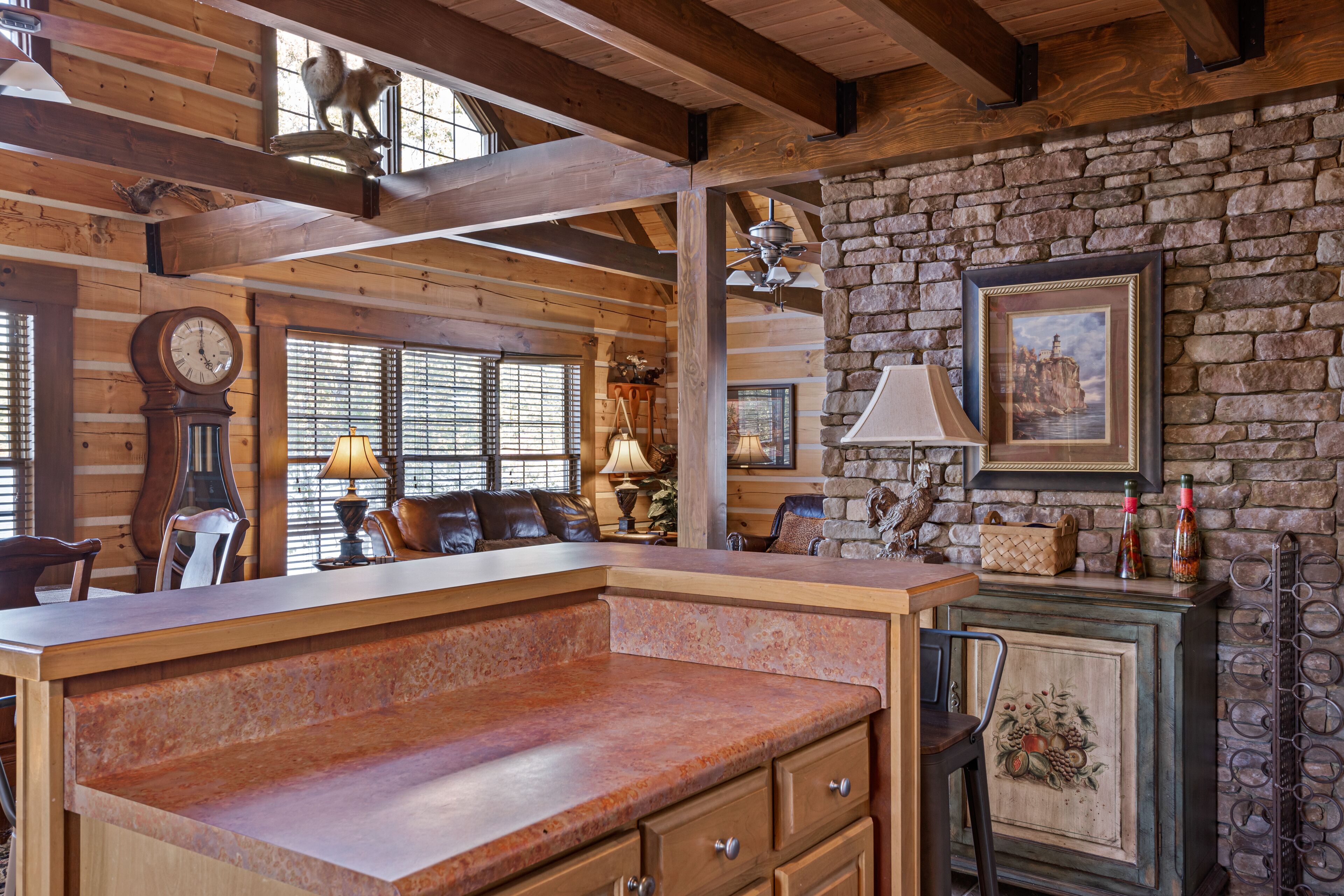 Un intérieur rustique avec des poutres apparentes, un mur en pierre et un comptoir en bois doté de tiroirs.