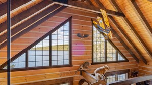 Una cabaña con interior de madera, ventanas amplias y vistas al exterior.