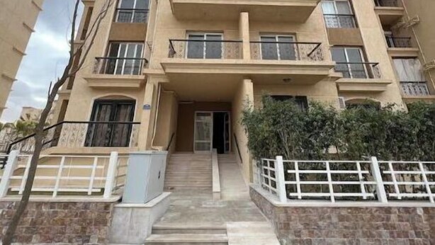 A multi-story residential building with balconies, a central entrance, and a stone facade. - Alrehab city luxury apartment (Cairo Governorate)
