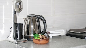 Eine Küche mit Kaffeemaschine, Wasserkocher und einer Schüssel mit Snacks auf der Arbeitsfläche.