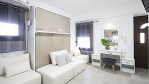 Ein modernes Schlafzimmer mit Schlafsofa, Schreibtisch und Spiegel.