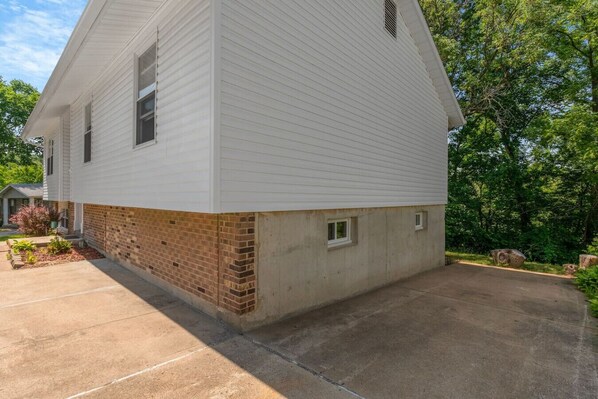 A two-story house with a brick foundation and white siding.