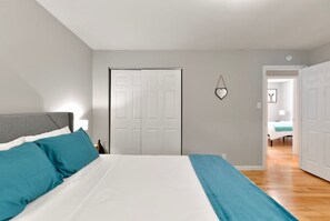 Un dormitorio con una cama, un armario y una puerta.