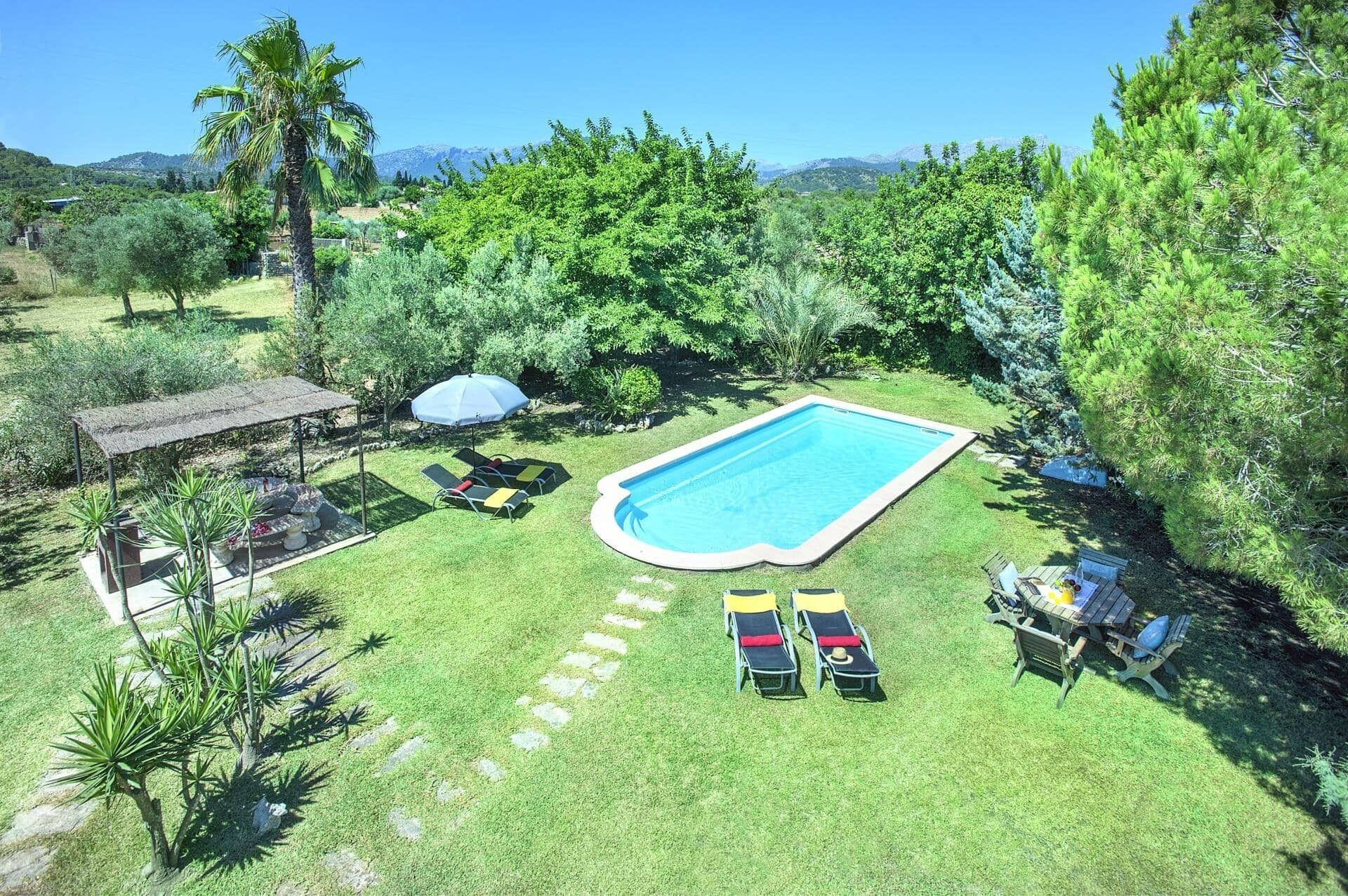 A backyard with a swimming pool, lounge chairs, a barbecue area, and a pergola.