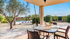 An outdoor patio with a pool, dining table, and chairs. - Villa Can Idu by Villa Plus (Mallorca)
