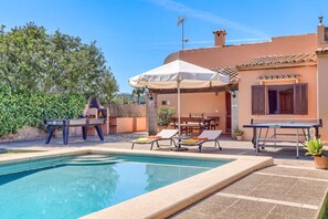 Un espace piscine équipé d’une table de ping-pong, de chaises longues et d’un barbecue.