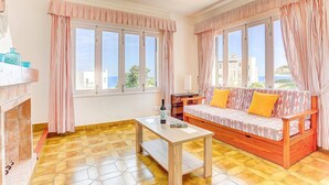 Una sala de estar con sofá, mesa de centro y chimenea.