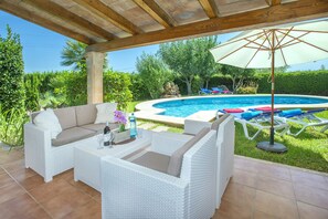 A covered outdoor area with a pool, white wicker furniture, and a pergola. - Villa Guaita II by Villa Plus (Mallorca)