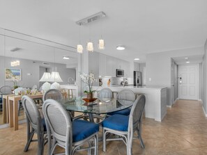 A modern kitchen with white cabinets, stainless steel appliances, and a central island with bar stools.