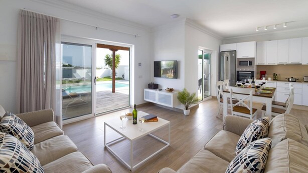 A spacious living area with a pool view, a dining area with a kitchen, and a modern design.