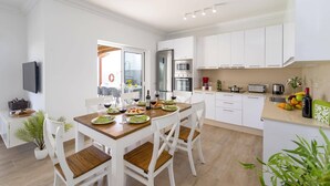 A modern kitchen with white cabinets, a built-in oven, and a microwave.