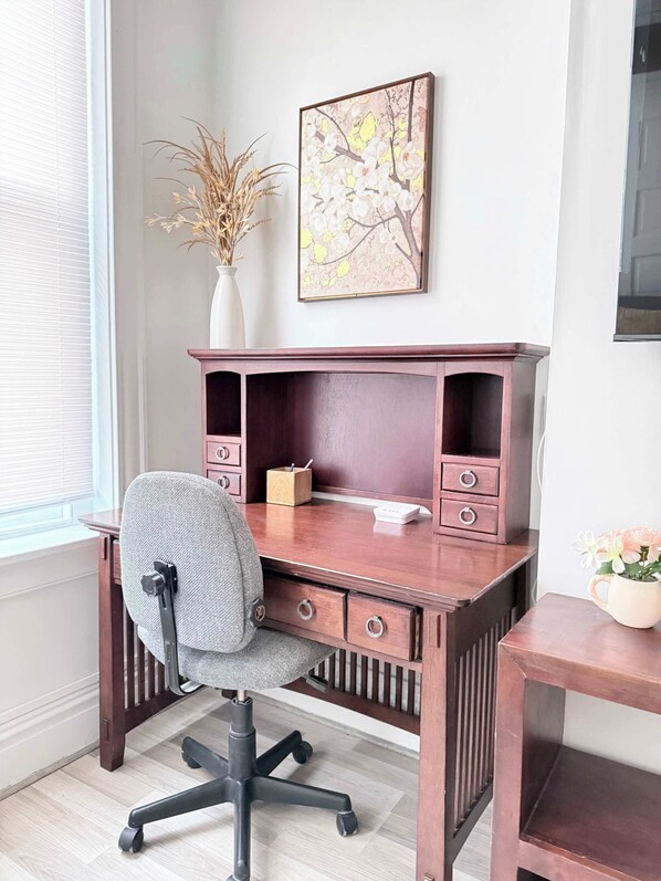 A wooden desk with a chair, a vase with dried plants, and a framed picture on the wall. - The Fan Comfort Stay near VCU Free Parking Fenced Yard (Richmond)