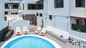 Ein Poolbereich mit Liegestühlen und Essbereich.