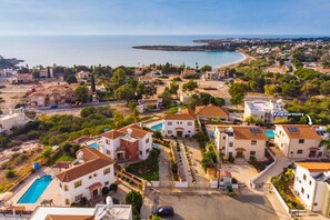 Villa Harmony, a residential area with houses, a swimming pool, and a view of the sea.