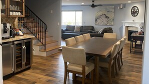 A spacious living area with a large dining table, a kitchen with a built-in oven, and a fireplace. - Hillside View Times Two (Arroyo Grande)