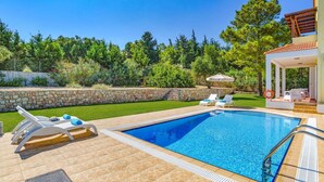A swimming pool with lounge chairs and a covered seating area. - Villa Ermis Springs by Villa Plus (Rhodes)