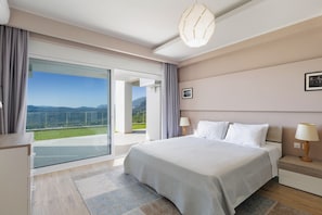Una camera da letto moderna con un ampio letto, vista sull'esterno e un balcone.