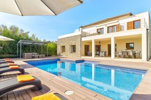 A modern house with a swimming pool, outdoor seating, and a covered patio. - Villa Casa de Pedra by Villa Plus (Crestatx)