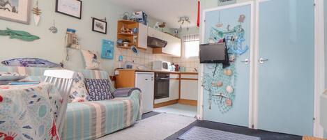 A cozy room with a bed, a small kitchenette, and a door labeled "Trevilla".