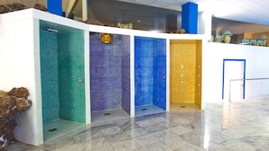 A modern bathroom with four distinct tiled walls in different colors. - RF La Quinta Park Suites (Santa Ursula)
