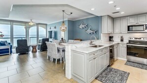 Una cocina moderna con armarios blancos, una isla grande y vistas al exterior.