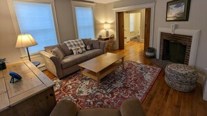 Ein Wohnzimmer mit einer Couch, einem Couchtisch und einem Kamin.