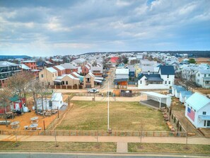 A residential area with houses, a flag, and a fenced area with tables.