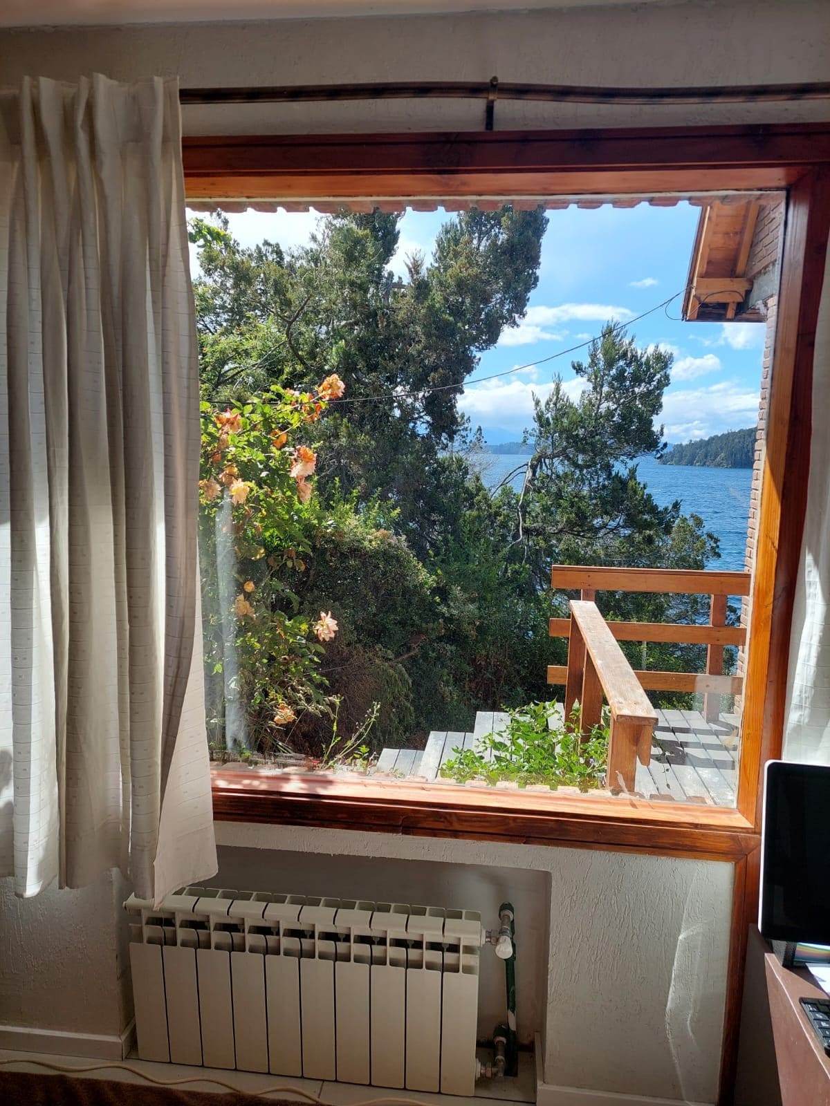Ein Zimmer mit Seeblick, einem Holzbalkon und einer Heizung.