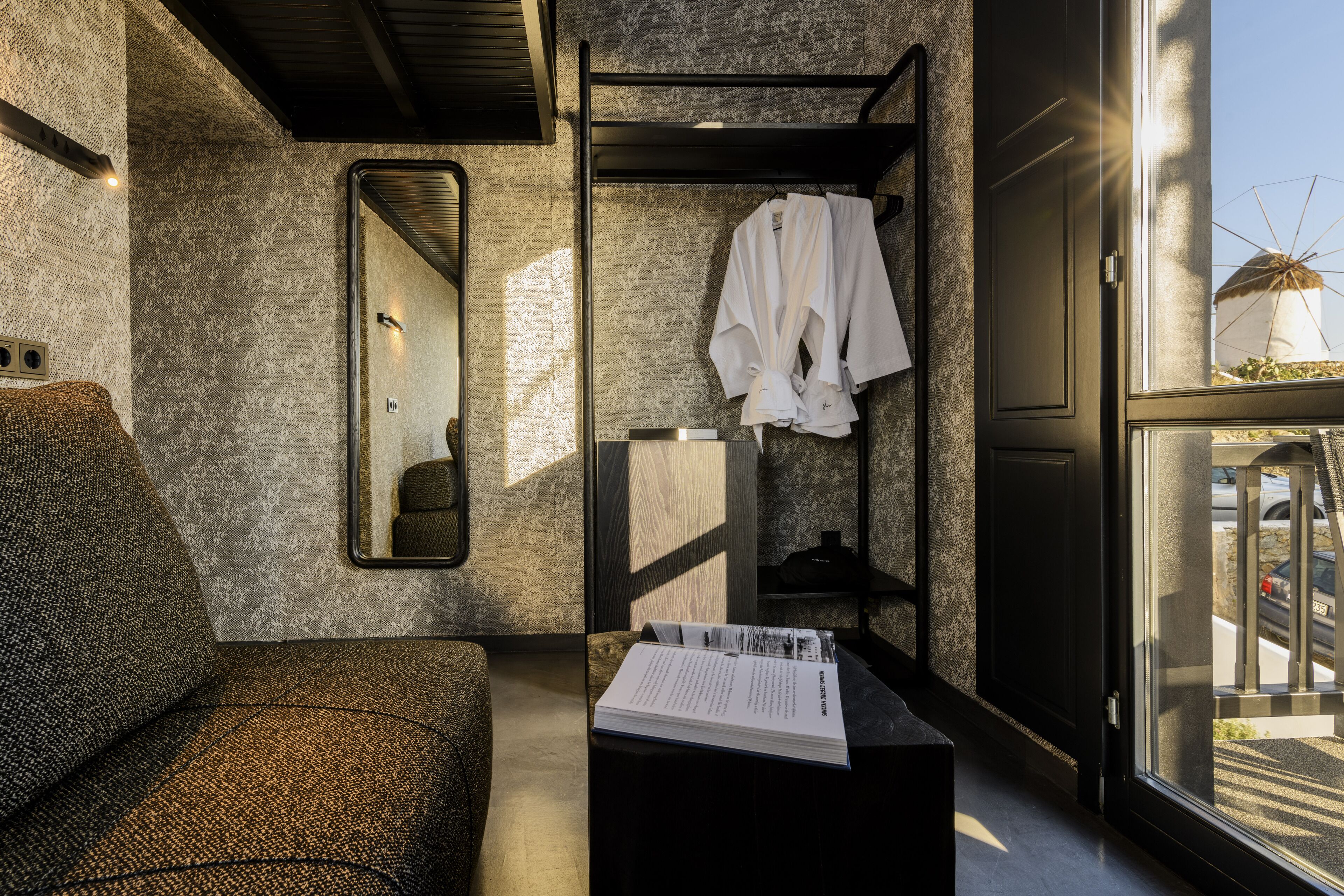 Un baño moderno con un espejo grande, un perchero para toallas y vistas a un molino de viento.