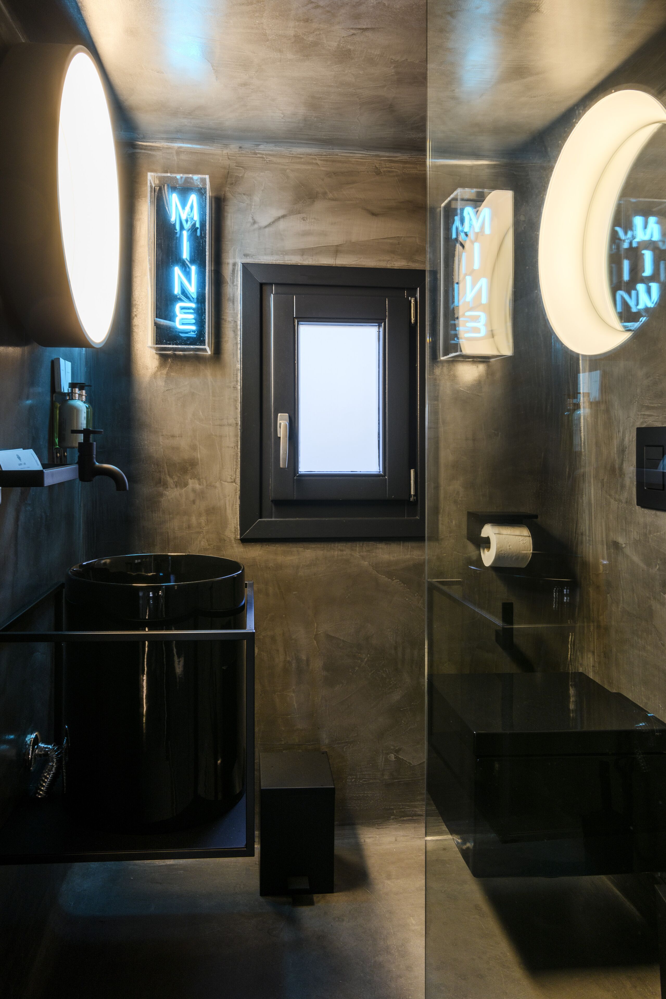 Une salle de bain moderne avec un grand miroir, une fenêtre et un néon.