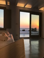 Una camera da letto con un letto, una finestra e vista sul tramonto.