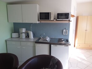 Kjøleskap, mikrobølgeovn, ovn og høy barnestol