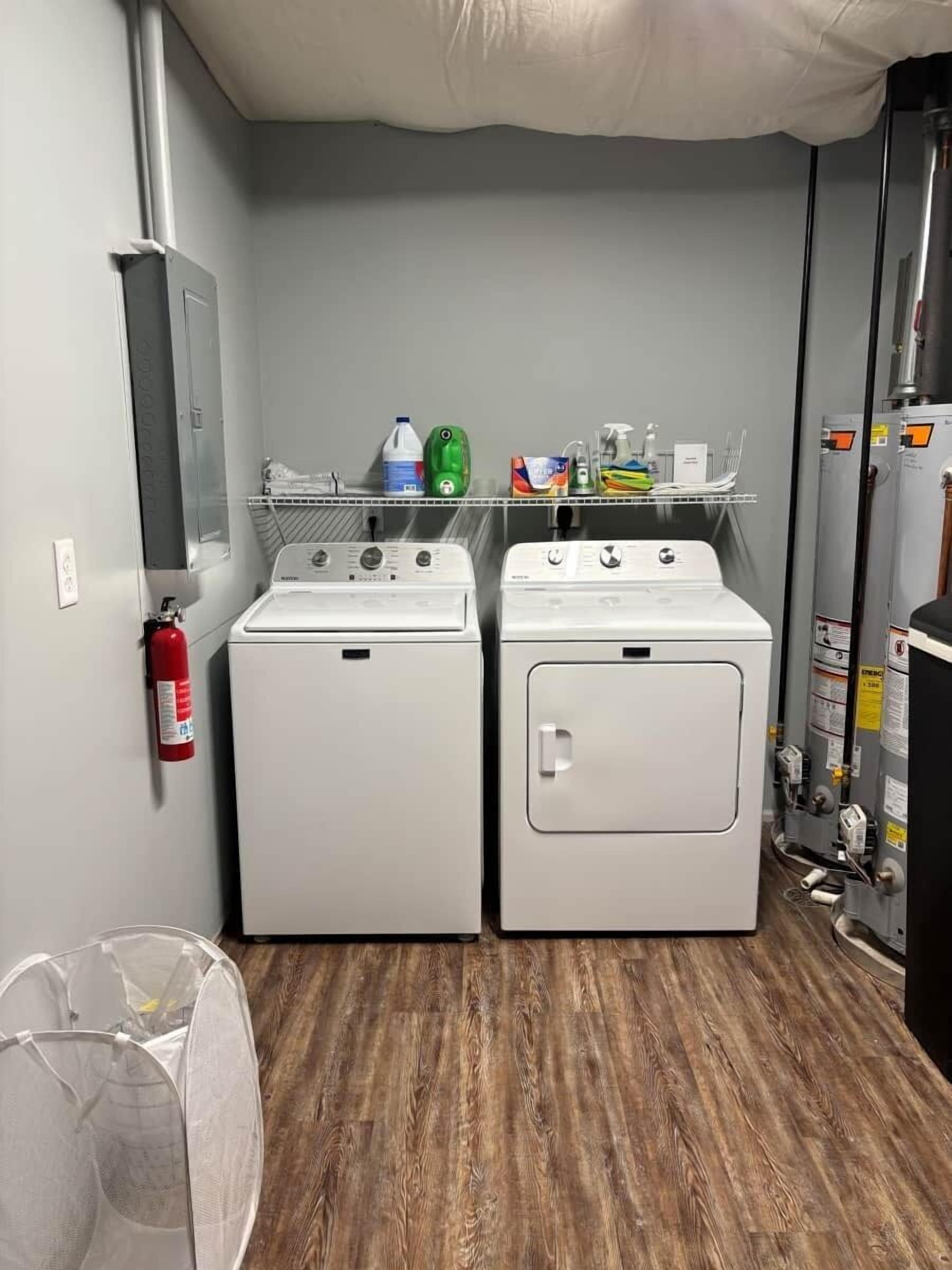Een wasserette met twee voorladers, een brandblusser en een plank met schoonmaakmiddelen.
