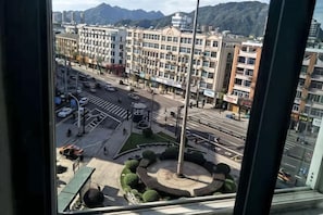 A cityscape with a roundabout, buildings, and a mountain in the background. - Liuwang Hotel (Pingyang)