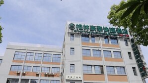 A multi-story building with a green sign indicating a hotel.