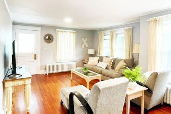 A living room with a sofa set, a coffee table, and a television on a stand. - Spacious Stamford Home | Family, Work, Parking (Stamford)
