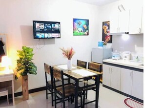 Cozy living space with a dining area, flat-screen TV, and kitchenette.