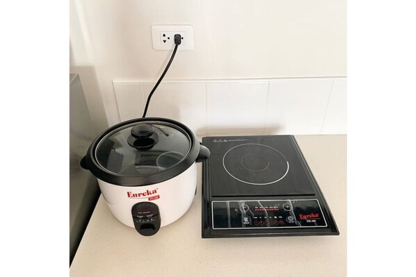 Effortless cooking is at your fingertips in this well-equipped kitchen, featuring a pressure cooker and induction cooktop.