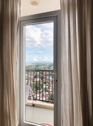 Enjoy a peaceful view from this balcony overlooking a residential area.