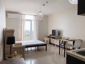 Enjoy a comfortable stay in this stylish room featuring a large bed, dining area, and a large window with a view.