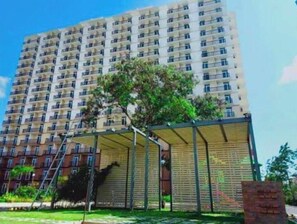 Stylish residential building with balconies and lush surroundings.