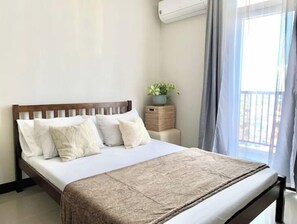 Relax in a cozy retreat with a neatly made bed, flanked by two pillows and a wooden headboard.