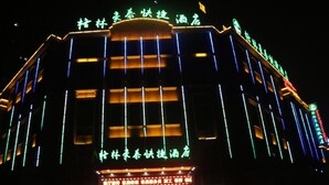 A hotel with illuminated signage and a modern facade. - Greentree Inn Hefei Feidong County High Speed Rail Station Wuyue Plaza Express Hotel (Hefei)