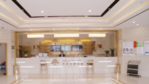 A hotel reception area with a clean, modern design, featuring a reception desk, seating area, and informational posters on the walls. - Greentree Inn Hefei Feidong County High Speed Rail Station Wuyue Plaza Express Hotel (Hefei)