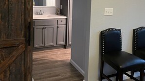A kitchen with grey cabinets, a white countertop, and a sliding barn door.