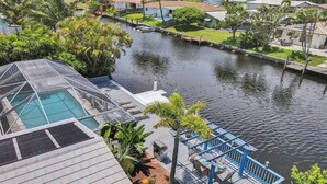 A residential area with a dock extending into a body of water, surrounded by houses and greenery. - Heated Pool-Waterfront 4BD Villa: Deck&BBQ (Fort Lauderdale)