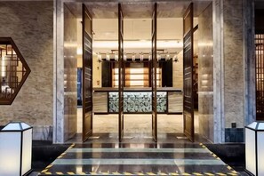 Een hotellobby met een receptiebalie, een incheckruimte en een ontvangstgedeelte.